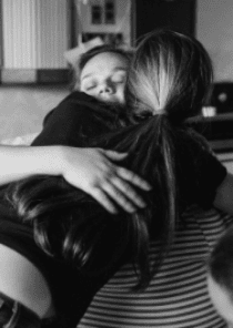 A bereaved mom shares a hug with her companion